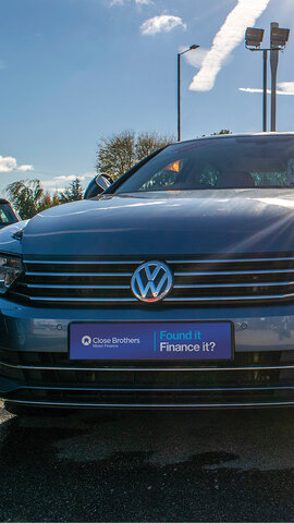 Volkswagen on forecourt with branded reg plate cover