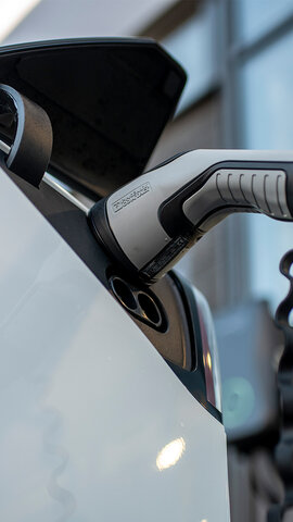 Electric vehicle being charged on forecourt