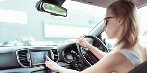 Female pressing screen inside car while driving
